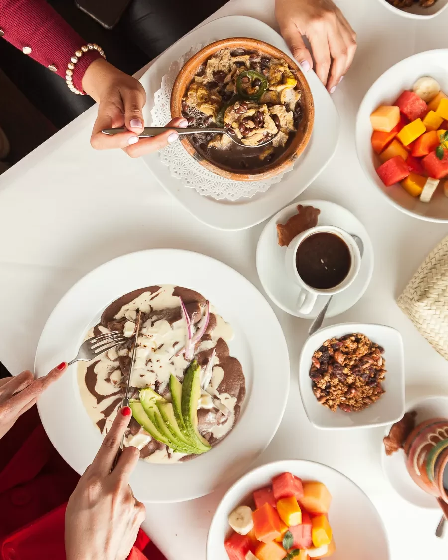 Mesa de desayuno con platillos poblanos, fruta, café y salsas